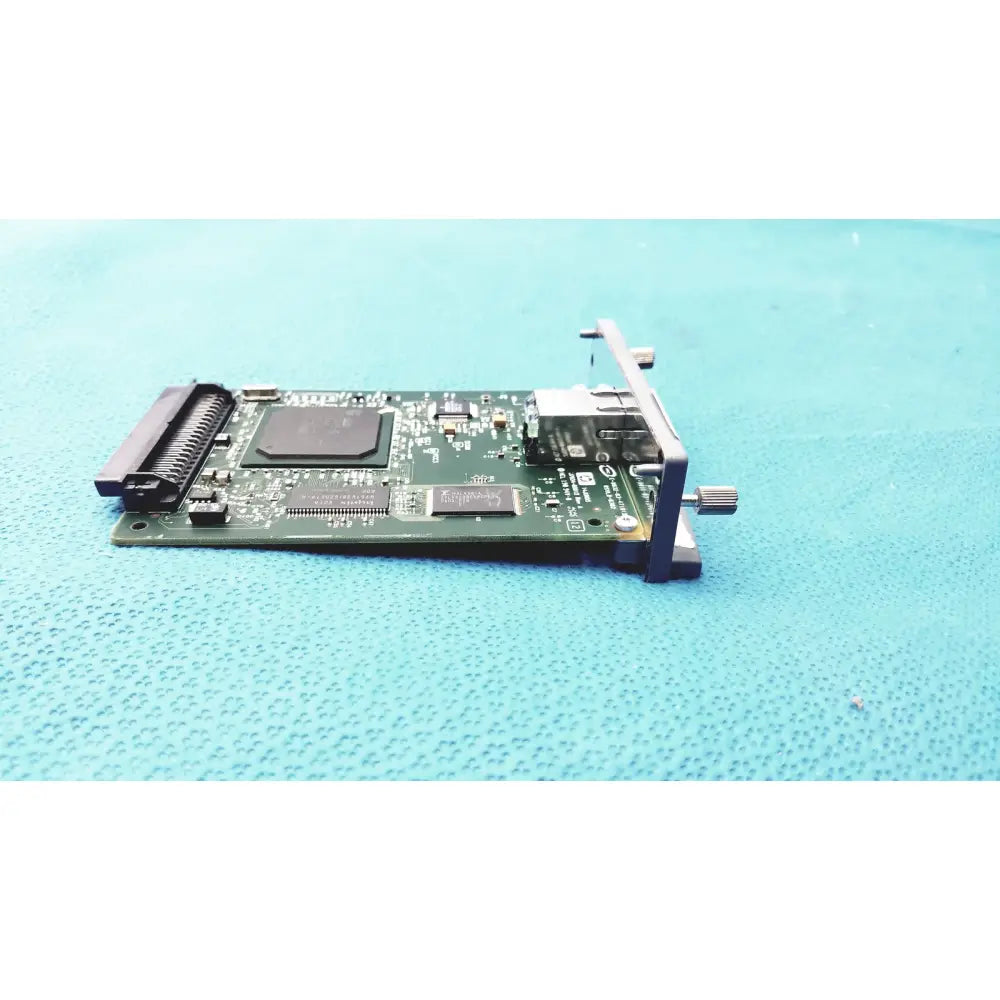 Green circuit board with black components and metallic bracket of hp jetdirect 620n fast ethernet print server