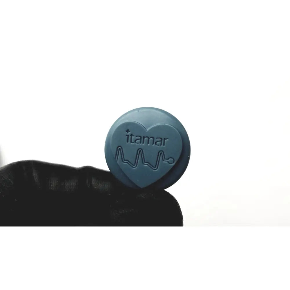 A teal-blue heart-shaped pill embossed with itamar and a heartbeat line for the itamar WatchPAT one home sleep apnea test kit