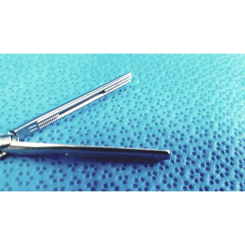 Jarit 610-140 roto-lok stainless steel clamp with serrated jaws silver surgical steel clamp on blue textured surface