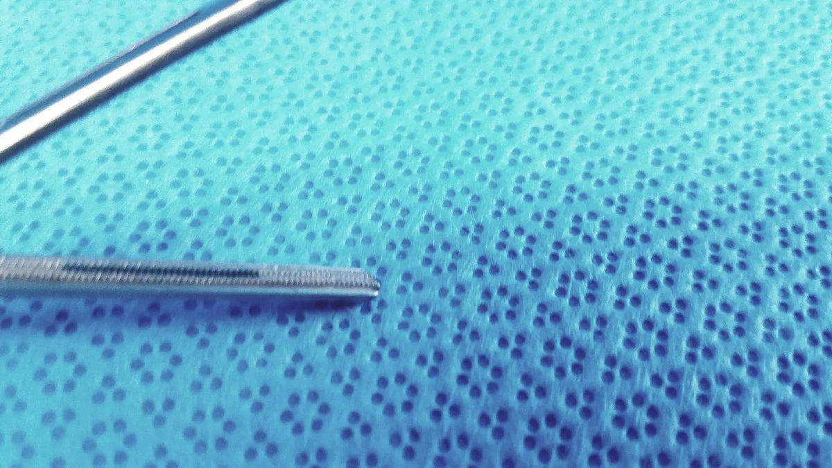 Silver Jarit 610-140 roto-lok stainless steel surgical instrument with textured tapered tip on blue perforated surface