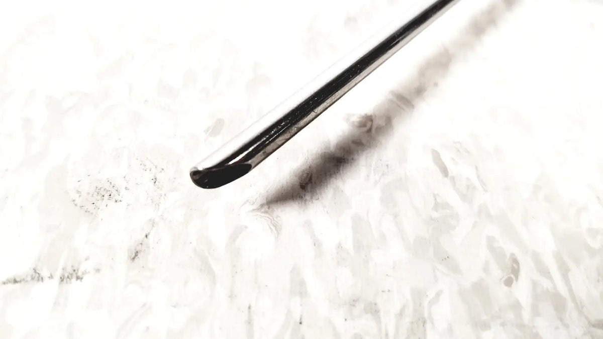 A sleek black metal crochet hook with polished finish and curved tip shown alongside karl storz 28124cr cannula