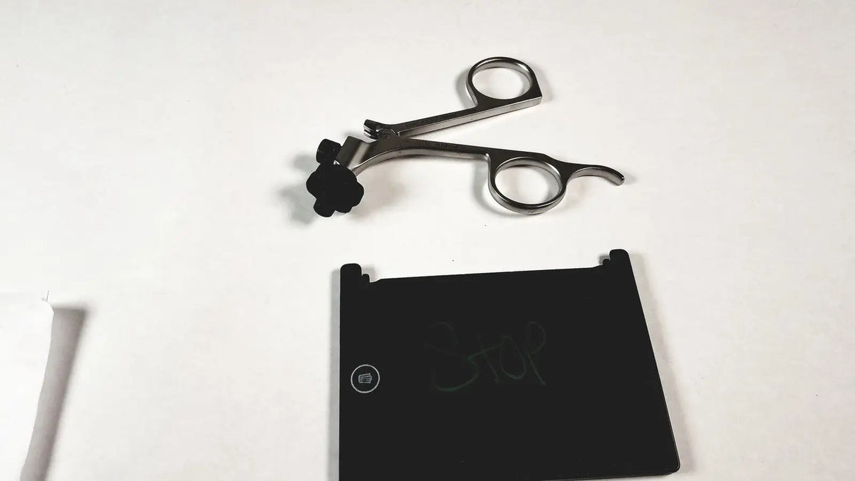 Silver surgical instrument with black rubberized grip and curved handles featuring karl storz clickline metal handle pistol grip