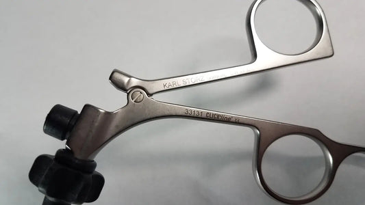 Silver surgical forceps with black rubberized handles branded karl storz clickline model 33131 for medical use