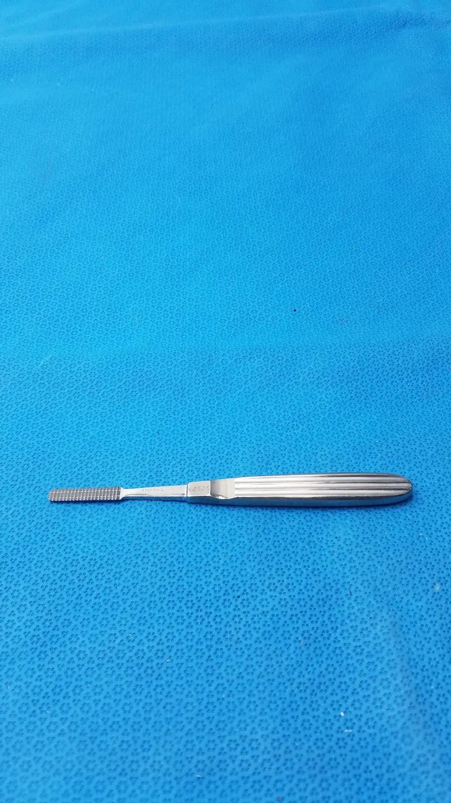 Silver karl storz stainless steel n4525 surgical instrument with textured ridged handle and fine comb-like tip