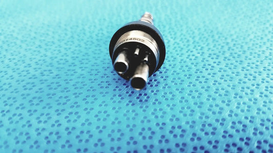 Black and silver led multiflex lux 6-pin coupler with three cylindrical ports for dental handpiece connection