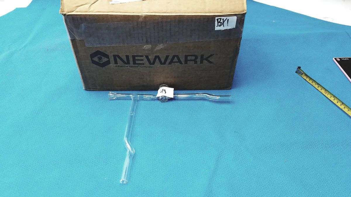 Laboratory glass decantor separator with clear t-shaped plastic tool, metallic joint, and white label for precise use