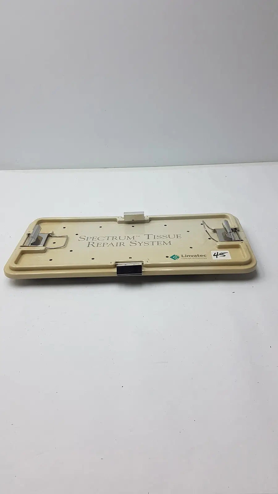 Beige plastic surgical tray with metal clamps and black latch labeled spectrum tissue repair system by linvatec concept arthroscopy