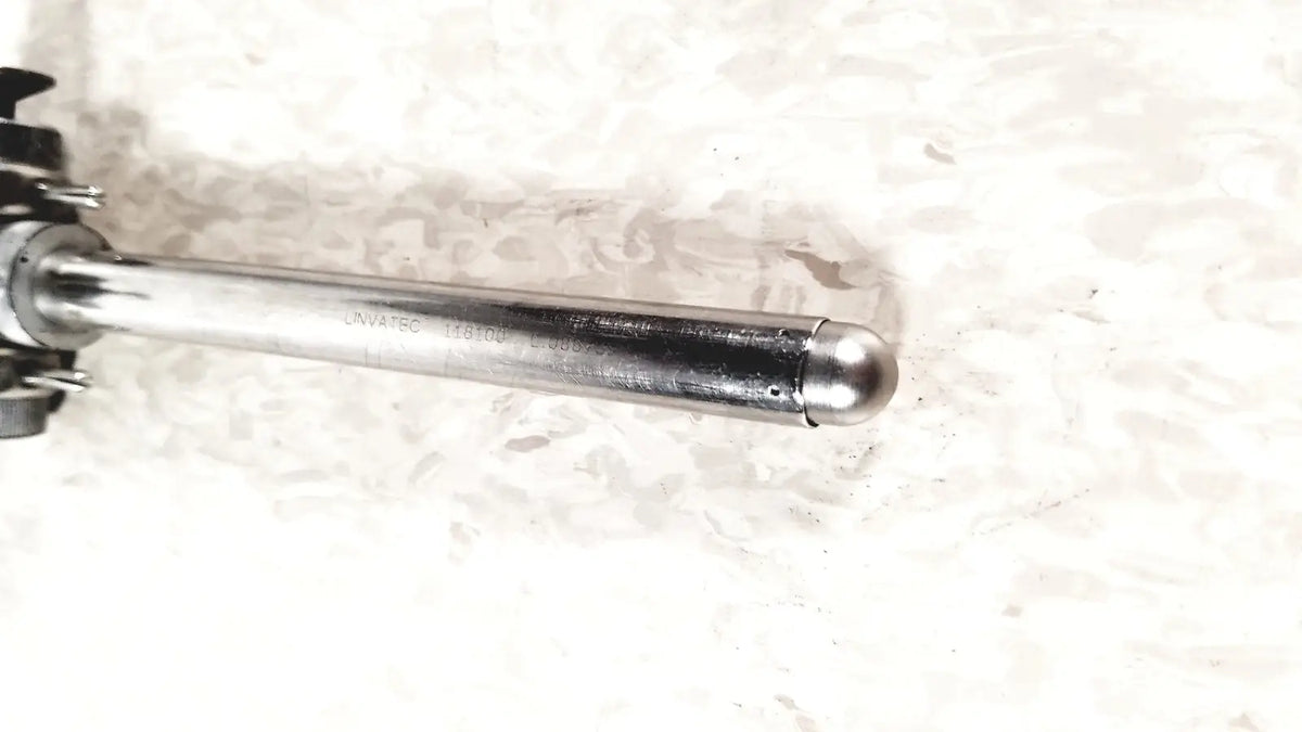 Silver metallic cylindrical laparoscopic valve with rounded end and engraved linvatec conmed model number 118100