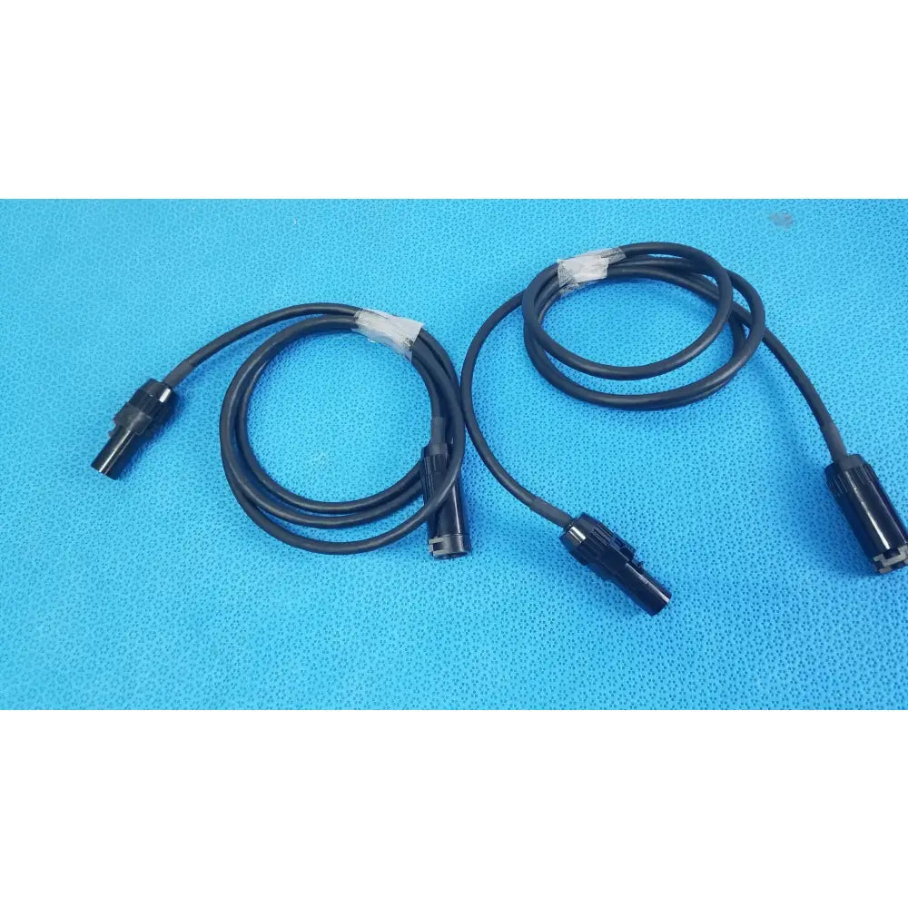 Lot of 3 black coiled mc4 solar connector extension cables with plastic connectors and white tape wraps for pv systems