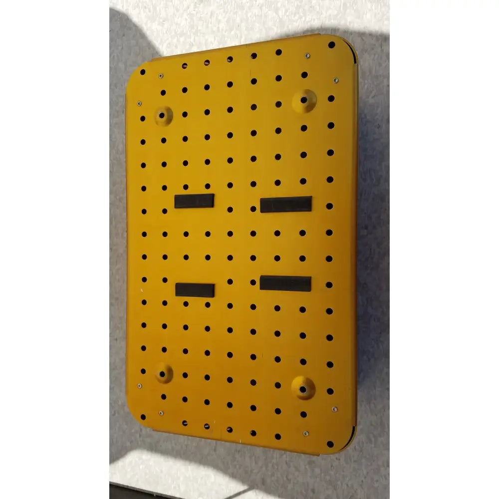 Bright yellow metal diffuser housing perforator driver with grid holes and four black rectangular strips empty case only