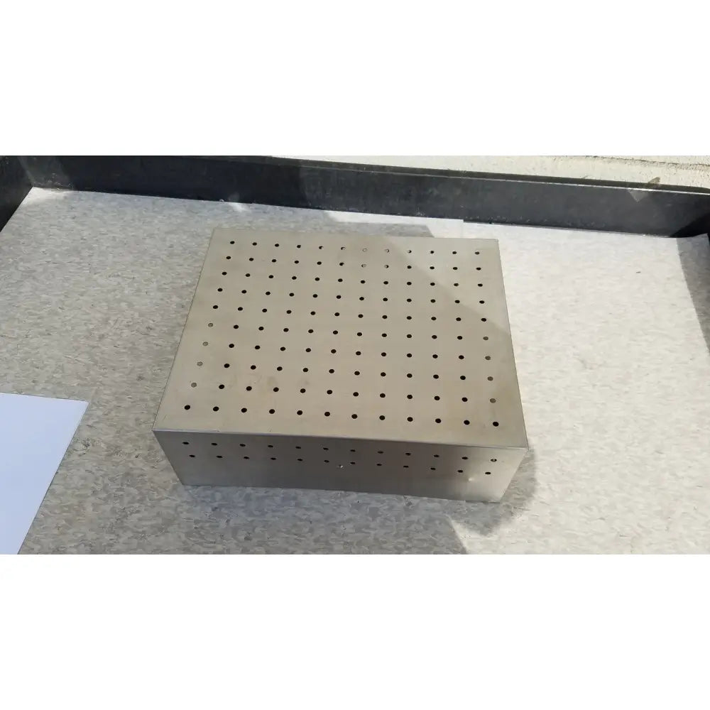 A square metallic perforated instrument sterilization basket with evenly spaced holes for medical dental instruments