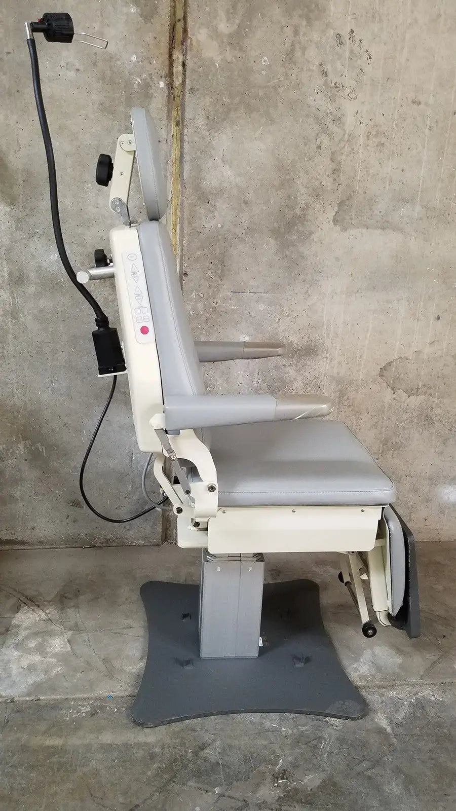 Gray and beige adjustable padded medical examination chair with armrests and headrest by medical technology industries power lift