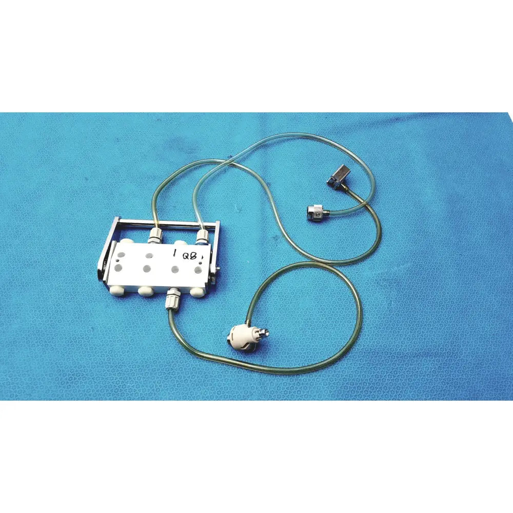 Silver surgical hook-up connector assembly medivators 907315 with multiple ports and green tubing attached to metallic connectors