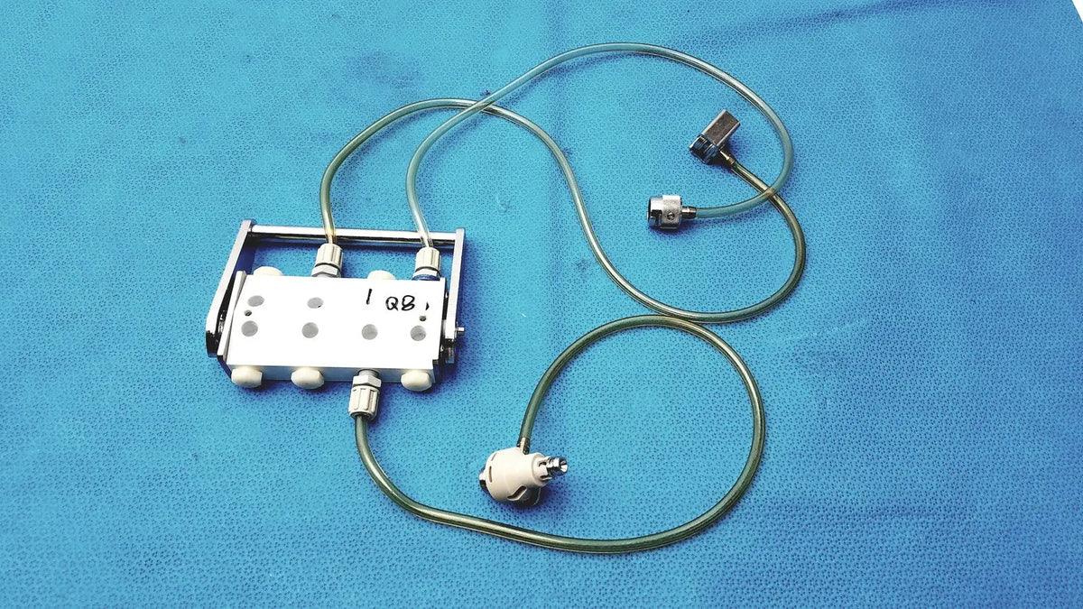 Silver surgical hook-up connector assembly medivators 907315 with multiple ports and green tubing attached to metallic connectors