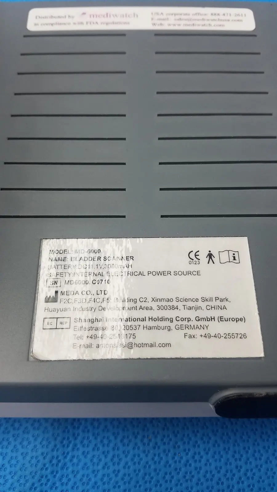 Gray plastic mediwatch md-6000 bladder scanner showing white label with technical specifications and manufacturer information