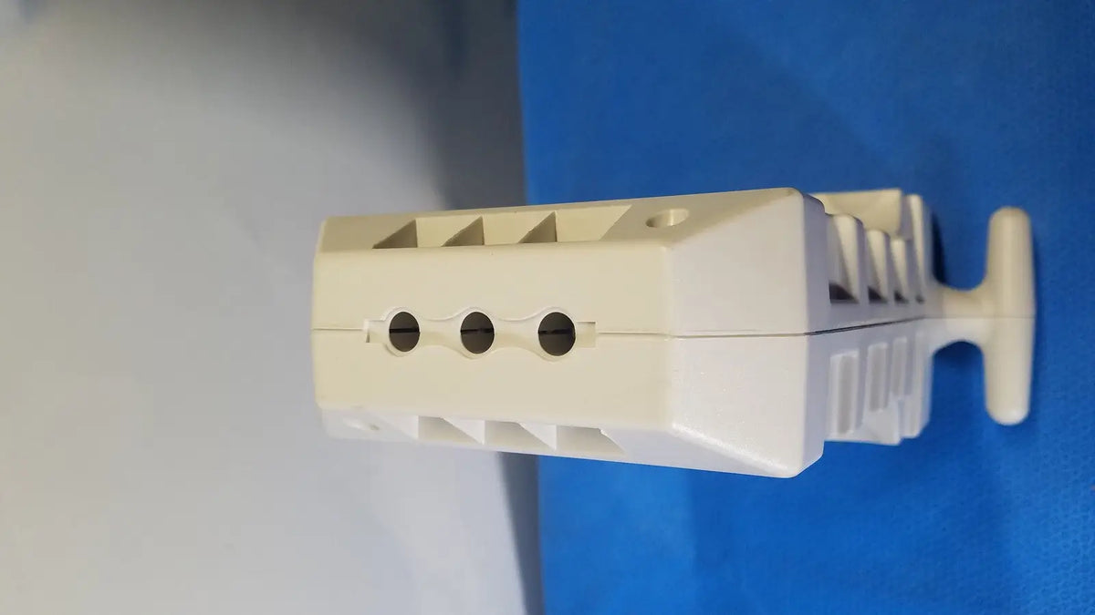 Off-white plastic electrical terminal block with three circular mounting holes and handle for medrad spectris solaris mr injection system battery