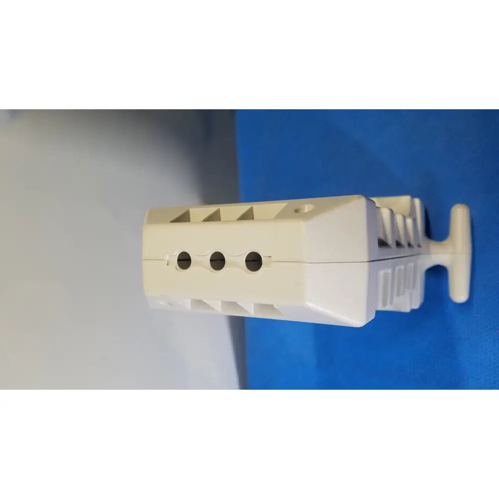 Off-white plastic electrical terminal block with three circular mounting holes and handle for medrad spectris solaris mr injection system battery