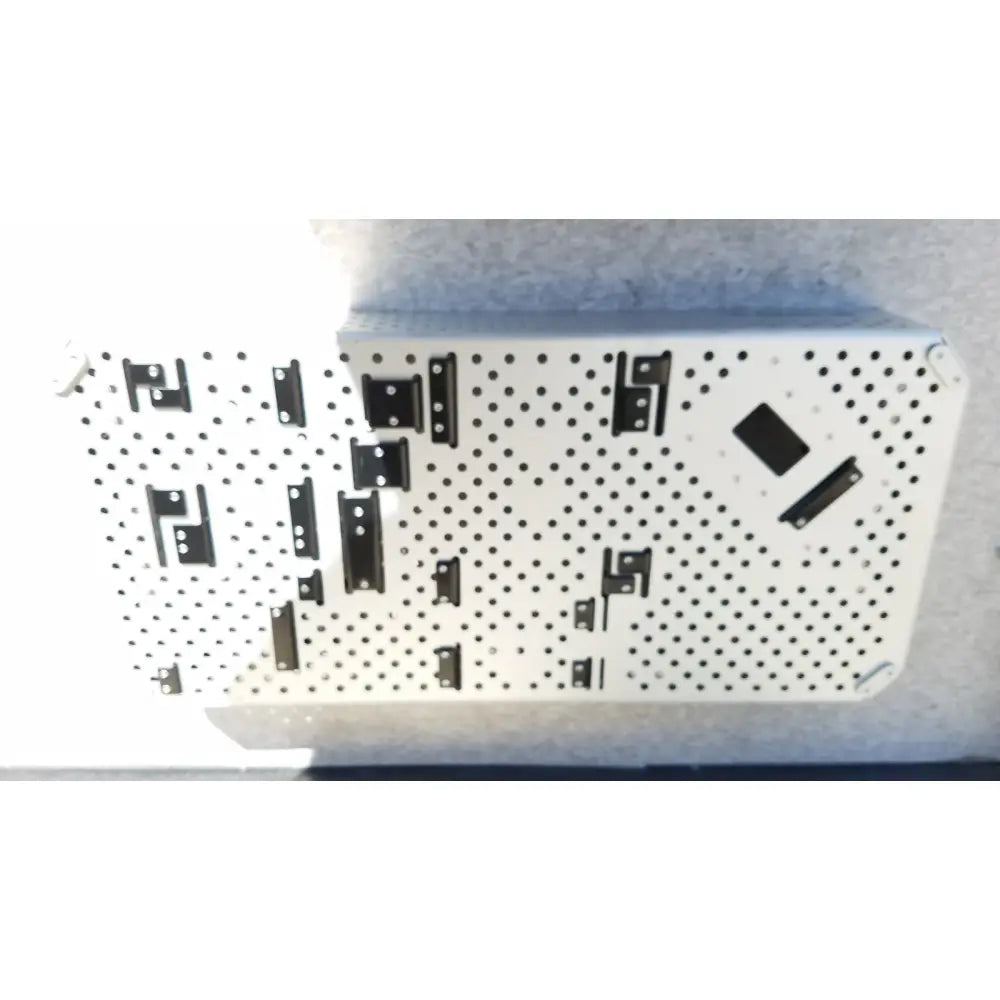 White perforated metal dilators tray with black l-shaped mounting brackets for reuse medical sterilization trays by medtronic