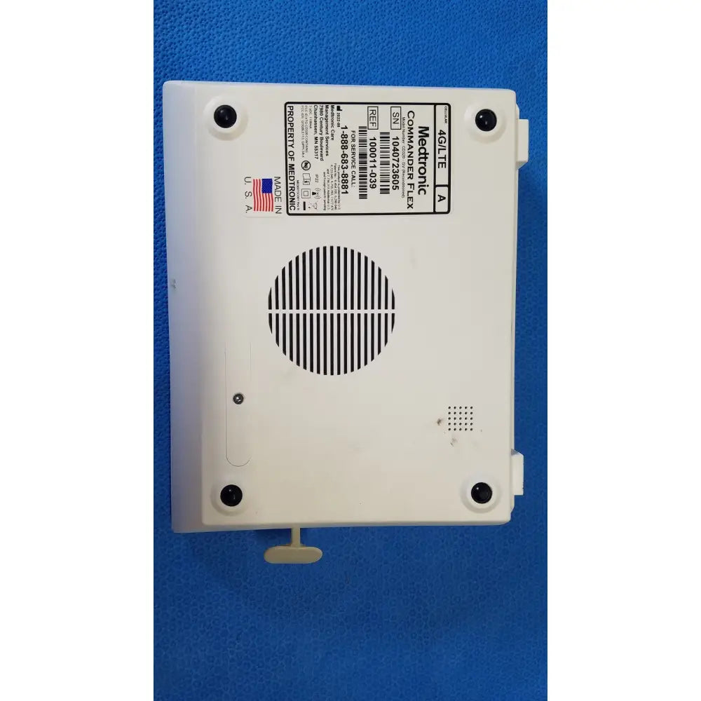 White plastic medtronic commander flex a4lite medical device back with circular vent grille and four mounting screws