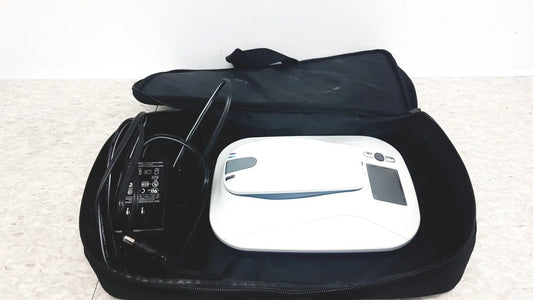 White robotic vacuum cleaner with black accents shown alongside medtronic mycarelink remote patient monitor model 24955