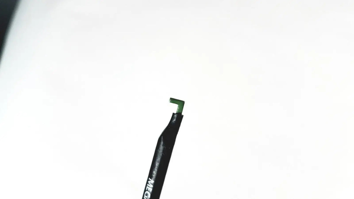 Black pen with green tip and white lettering on barrel of megadyne e-z clean l-hook laparoscopic electrosurgical instrument