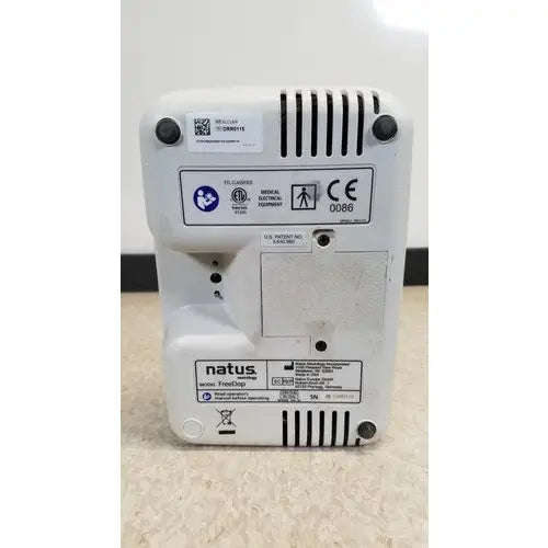 White plastic natus neurology freedop xld004 medical electronic device with ventilation slits and regulatory labels back view