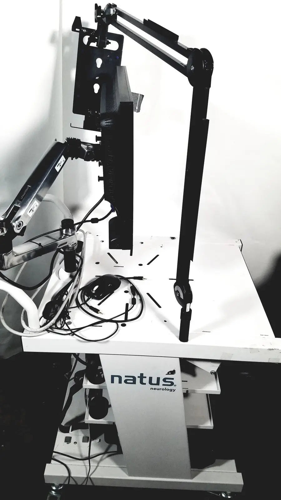 Black articulated arm monitor stand mounted on white mobile cart with natus neurology nicolet edx base system branding