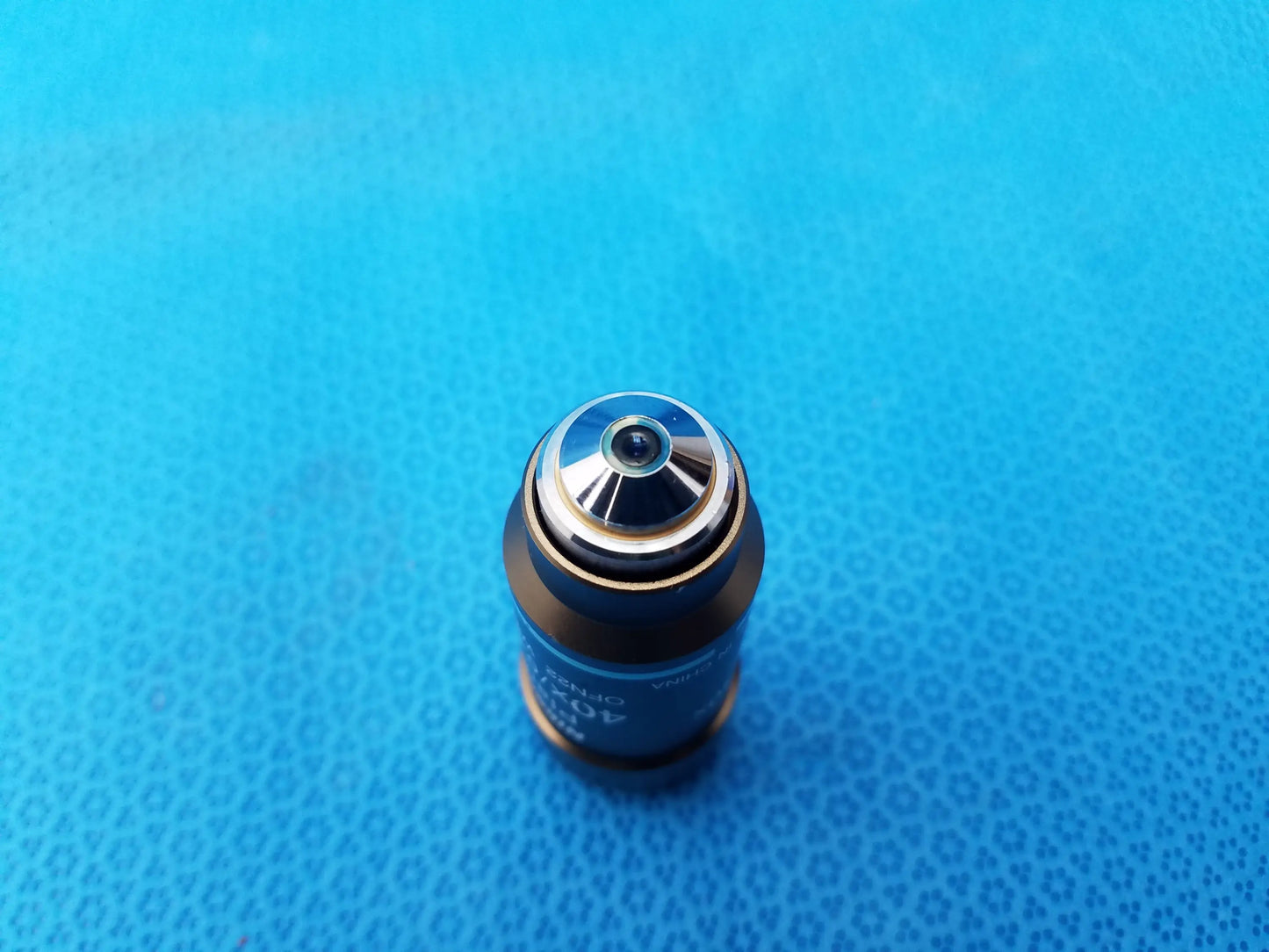 Blue cylindrical microscope objective with metallic silver top and engraved markings for nikon microscope systems
