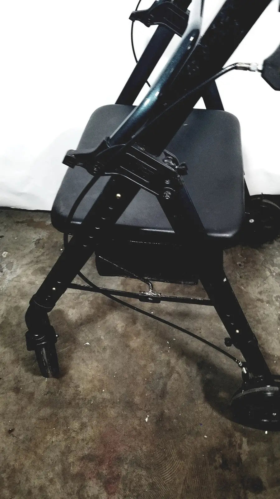 Black metal nova lightweight transport chair with padded seat and four wheels suitable for 300lbs capacity use