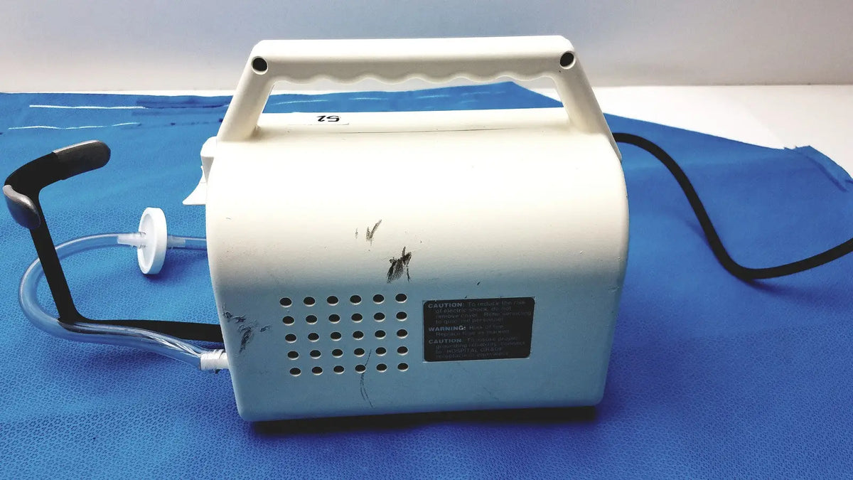 White plastic Ohio Care-E-VAC 3 portable suction pump medical unit with black handle and tubing for medical use