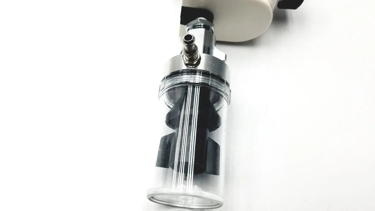 Clear cylindrical ohio vacuum regulator with black internal parts and metallic top attached to white device model pisa