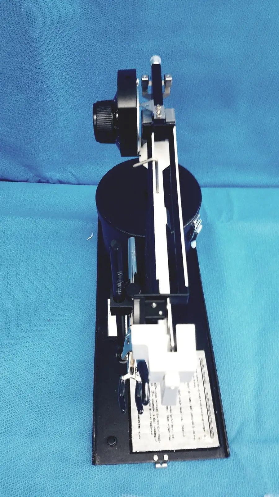 Black metal optical bench with adjustable components and mounted lens assembly for ohmic instruments ultrasound power meter scale