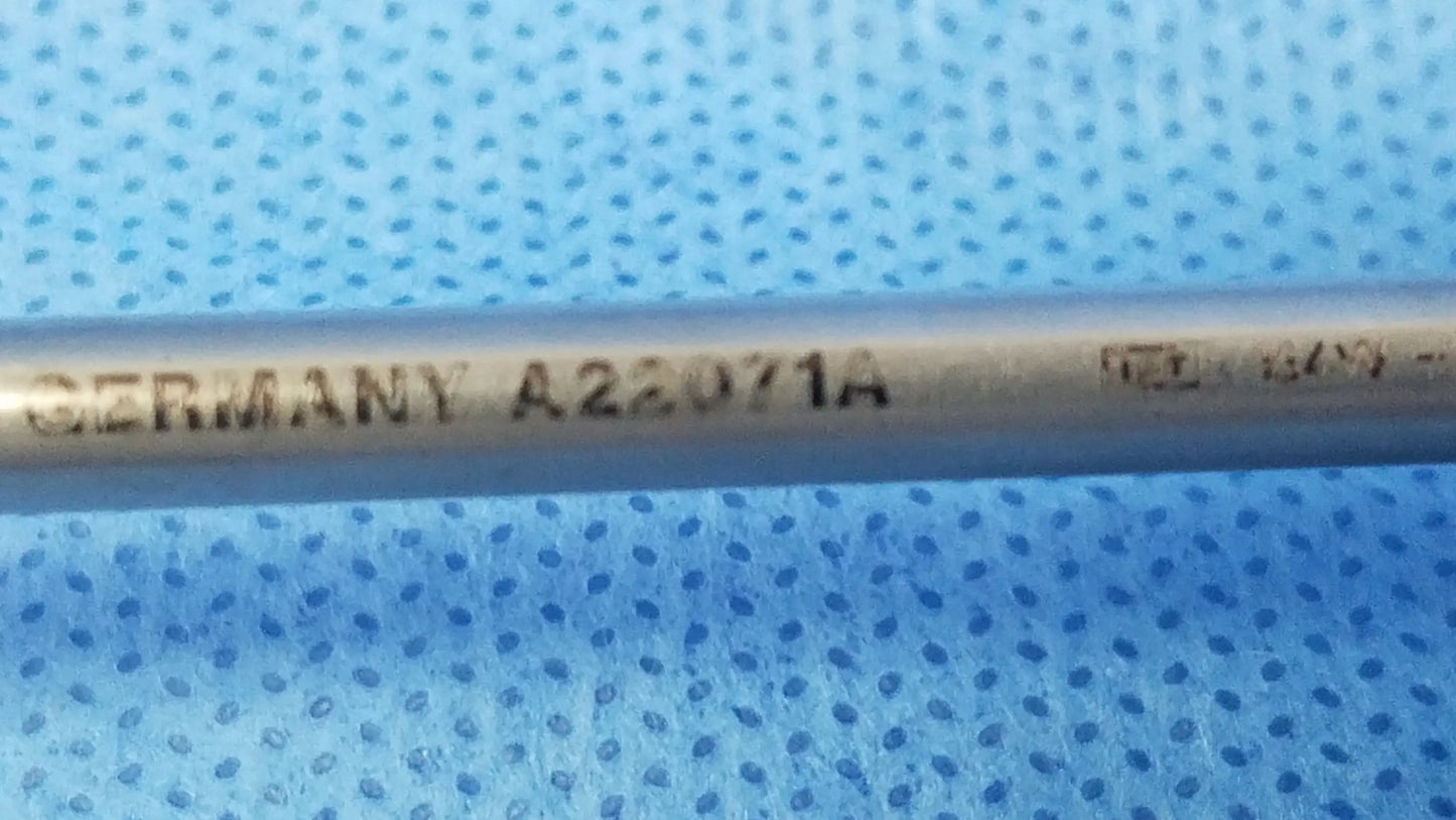 A metallic olympus a22071a visual optical obturator with engraved markings on a blue perforated surface