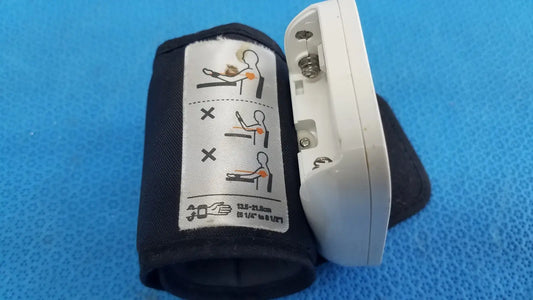 White omron automatic wrist blood pressure monitor with black cuff featuring instructional diagrams and size specifications