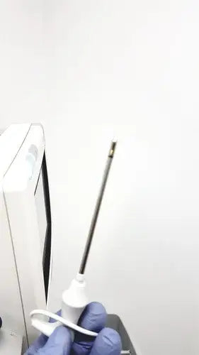 A white medical needle with black shaft and metallic tip held in gloved hands for philips intellivue mp5t patient use