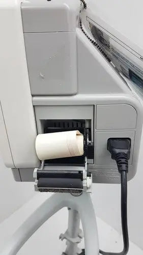 White cylindrical paper roll loaded into gray industrial printer on philips intellivue mp5t patient monitor rolling stand