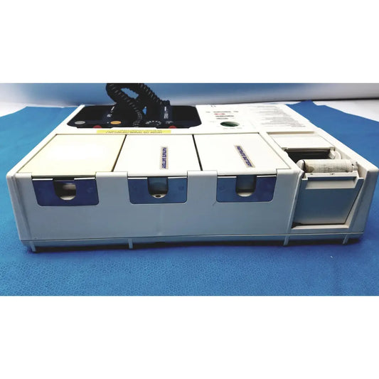 White and blue physio control lifepak 10 cardiac monitor with three labeled compartments and open paper roll compartment
