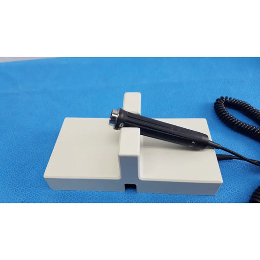 Black handheld endoscope with metallic tip on white stand for ri-former diagnostic station extension module