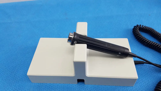 Black handheld endoscope with metallic tip on white stand for ri-former diagnostic station extension module