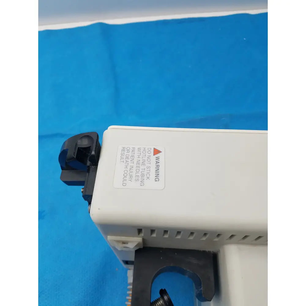 White plastic smiths medical fluid warmer control box unit with black components and a warning label for medical equipment