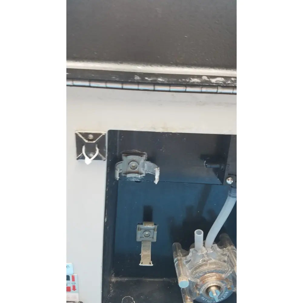 Gray metal latch with circular handle on dark surface of sorvall instruments cell washer 2 model 8701716