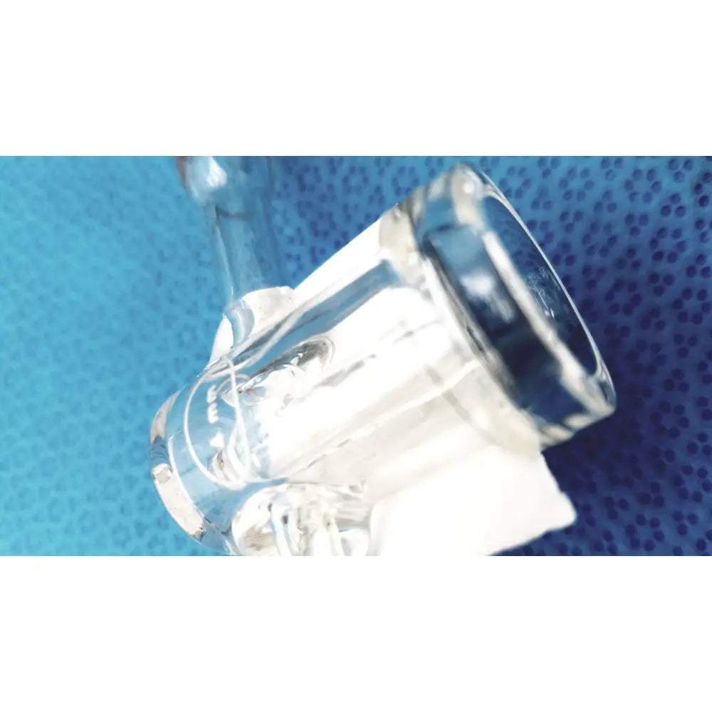 Clear glass bong with curved bowl and metallic accents featuring a spherical joint glass stopcock valve adapter