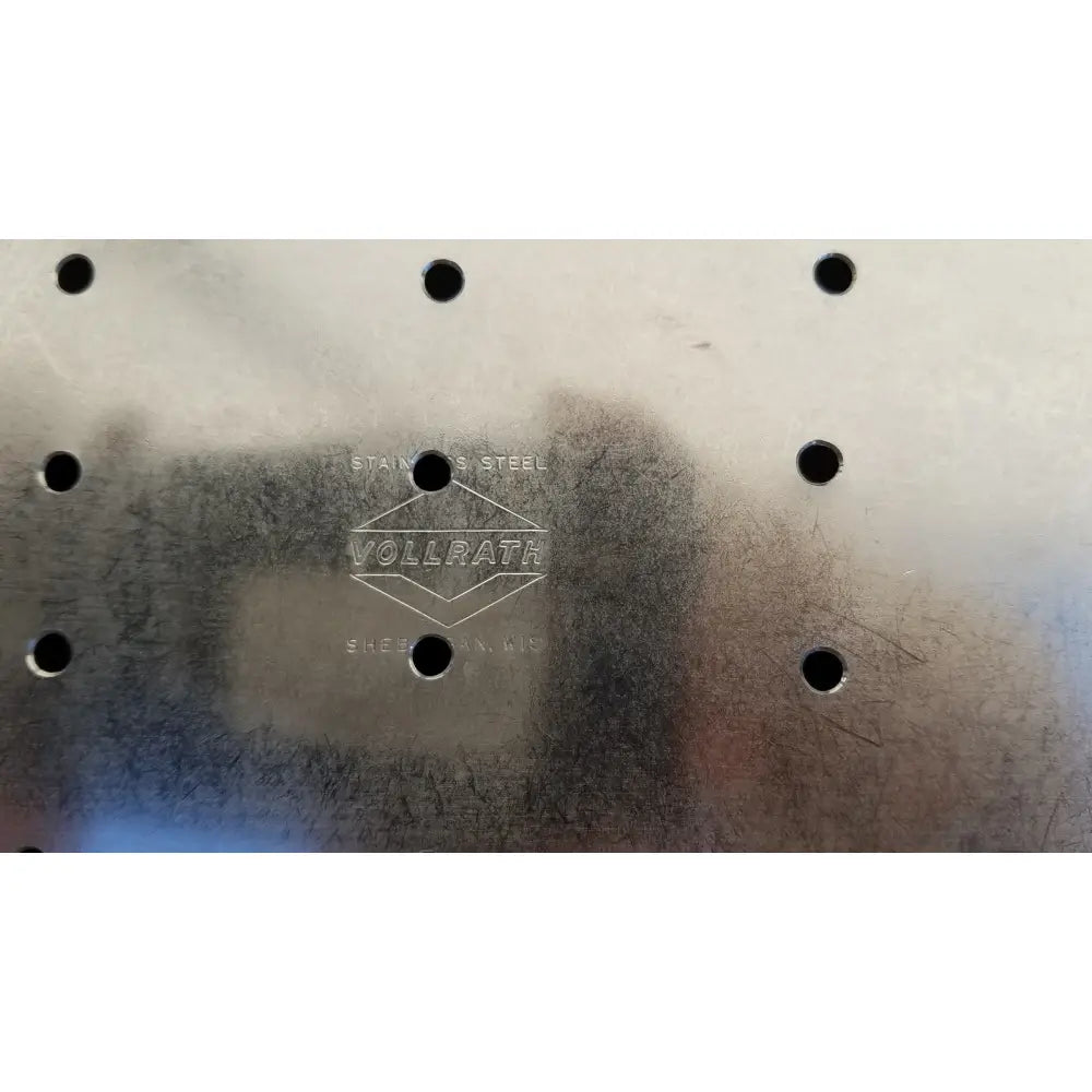 Stainless steel vollrath colander with embossed logo and evenly spaced holes for vollrath sheboygan tray use