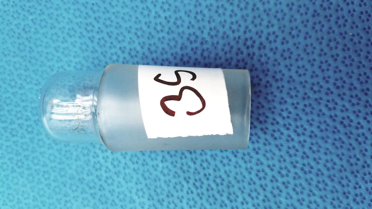 A translucent frosted glass vial with a standard taper no 29 brown label and a clear borosilicate glass hollow stopper