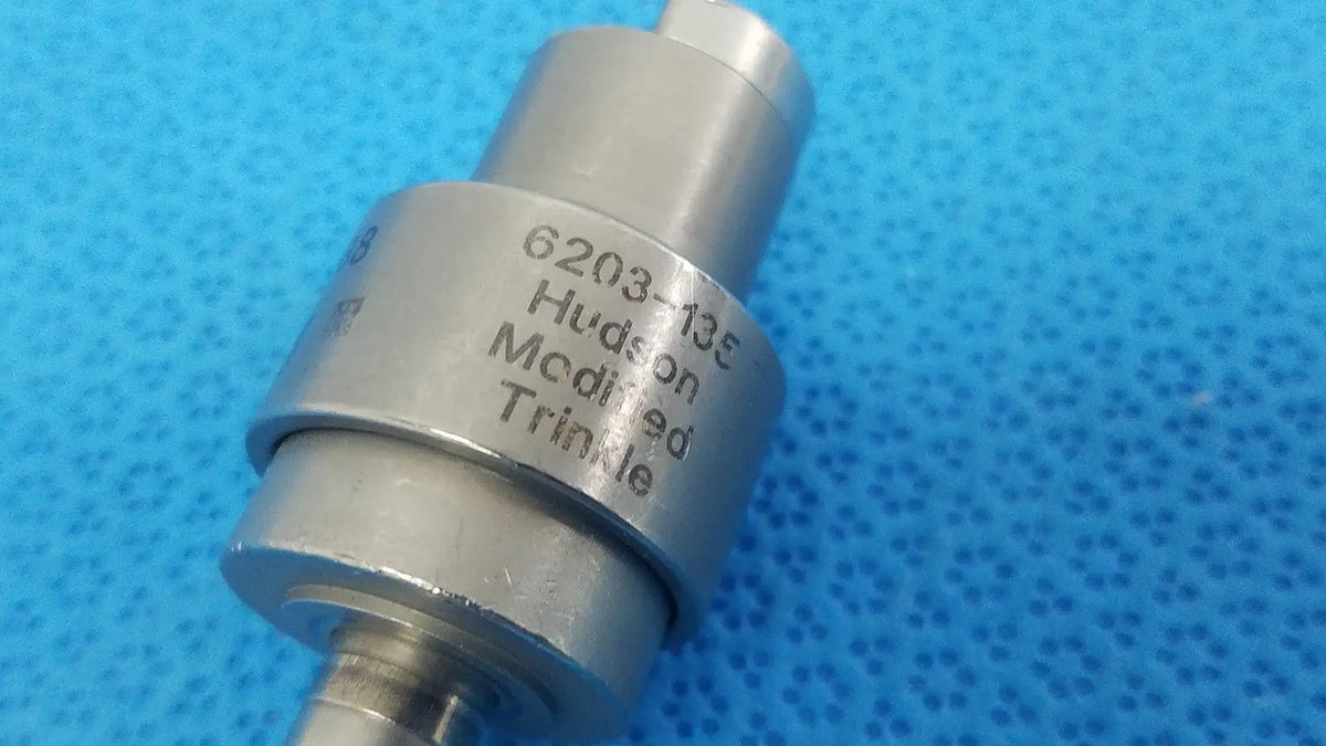 Silver metallic cylindrical stryker hudson modified trinkle attachment with engraved 6203-135 marking