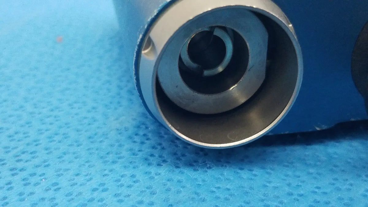 Silver metallic cylindrical connector with threaded interior and concentric rings for Stryker remb universal driver