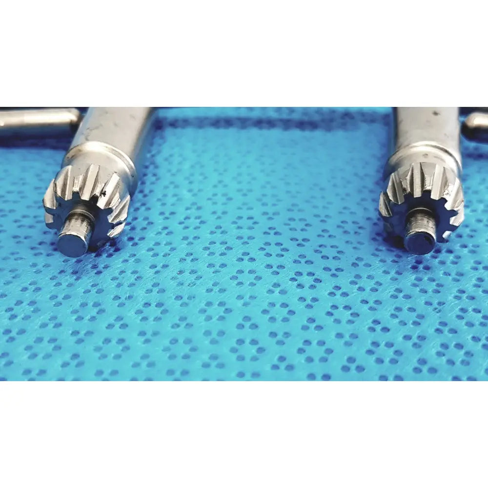 Silver stryker chuck key dental handpieces with gear-like tips resting on blue textured surface lot of 4 precision tools