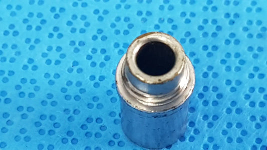 Silver metallic cylindrical stryker light post adapter with threaded interior and worn edges for fiber optic cables