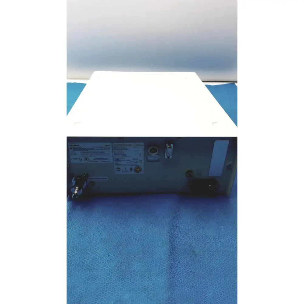 White rectangular stryker pneumo sure xl high flow insufflator with metallic back panel showing ports and connectors