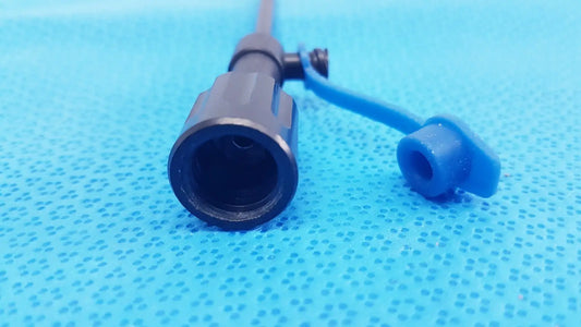 Black plastic surgical cannula sheath with luer lock and distal tip featuring a blue cap and connector